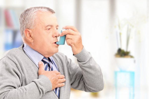 Hombre que trata el asma con inhalador